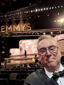 A closeup of Principato with the Emmy's stage in the background