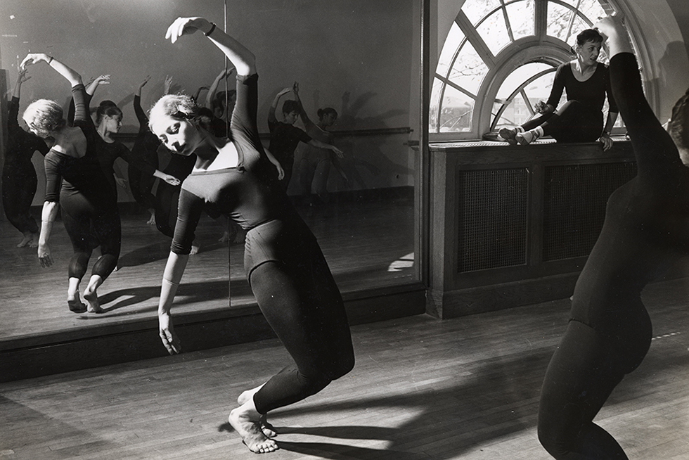 A student dancer in the studio performs one of the core movements in modern dance.