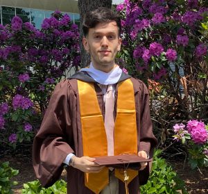 Bennis Sujak ’21, MA ’24 in his graduation robe.