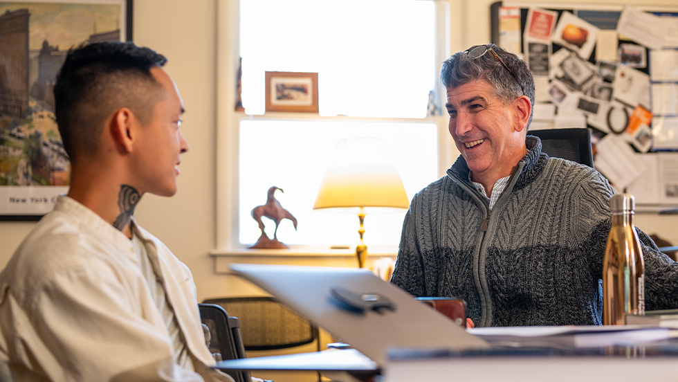 A student speaking to a professor in an office setting